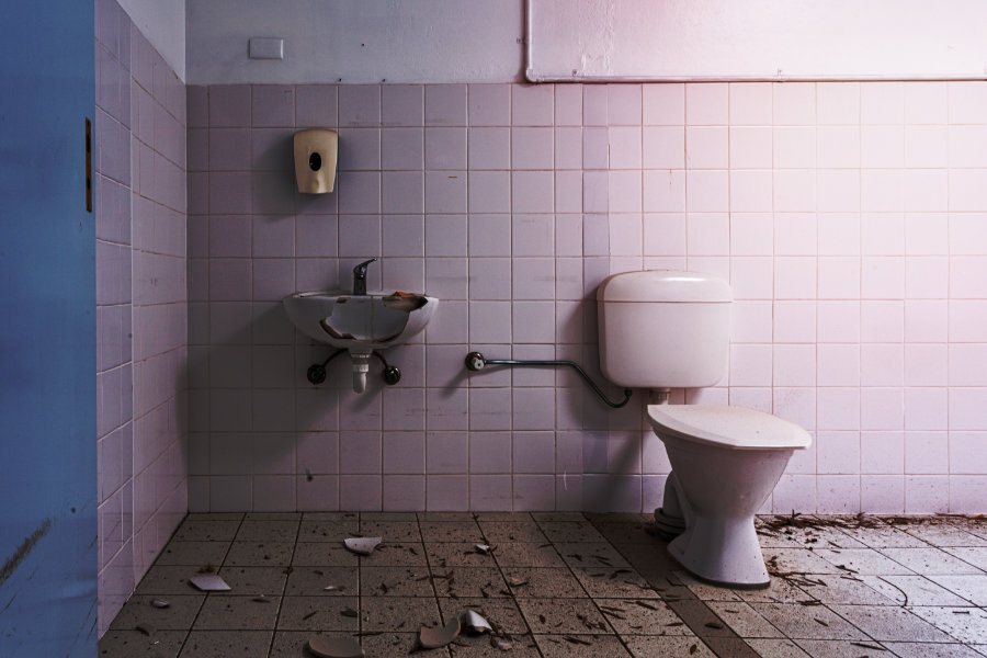 Das Bild zeigt ein demoliertes Waschbecken in einem Badezimmer. Das Bild symbolisiert das Opfer einer Mietnomade. Eine Mietnomade ist eine Person, die ihre Miete vorsätzlich nicht zahlt und bis zur Zwangsräumung in der Wohnung ausharrt und sie meist völlig zerstört. 